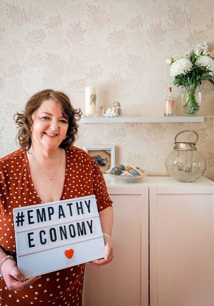 Jacqui's Virtual Photo Shoot Dr Jacqui Taylor with Empathy Economy Sign